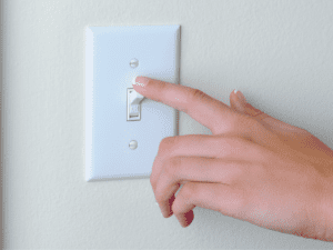 homeowner turning on light switch